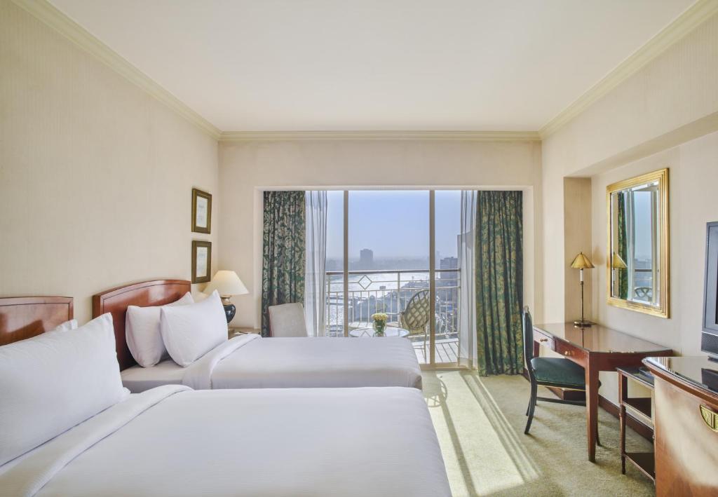سرير أو أسرّة في غرفة في Hilton Cairo Grand Nile