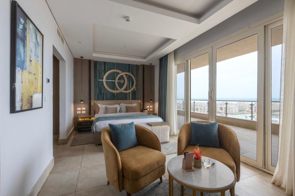 Gewan Resort New Alamein في العلمين: غرفة فندق بها سرير وطاولة وكراسي