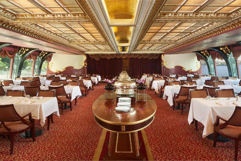 Hilton Cairo Grand Nile في القاهرة: غرفة طعام بها طاولات وكراسي بيضاء