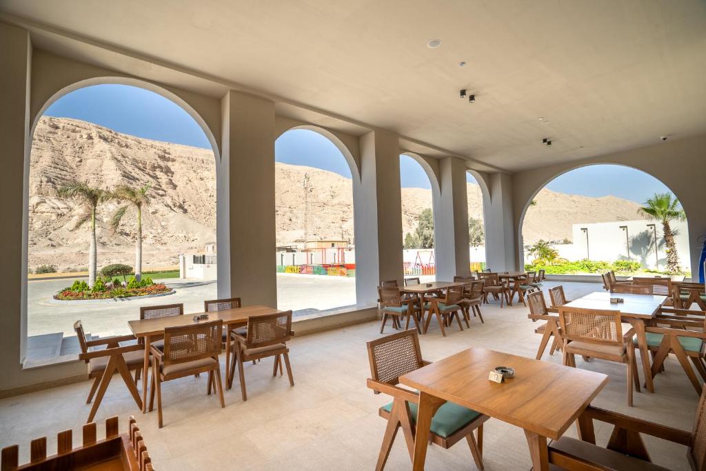Al Masa Hotel El Sokhna في العين السخنة: مطعم به طاولات وكراسي ونوافذ