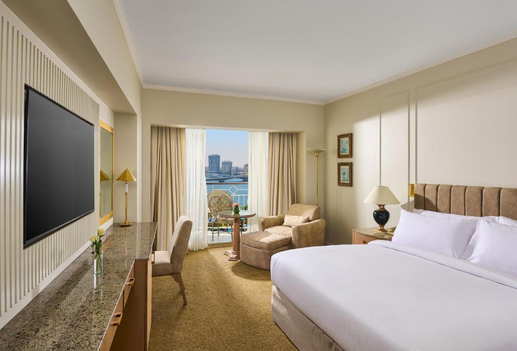 Hilton Cairo Grand Nile في القاهرة: غرفة فندق بها سرير وتلفزيون