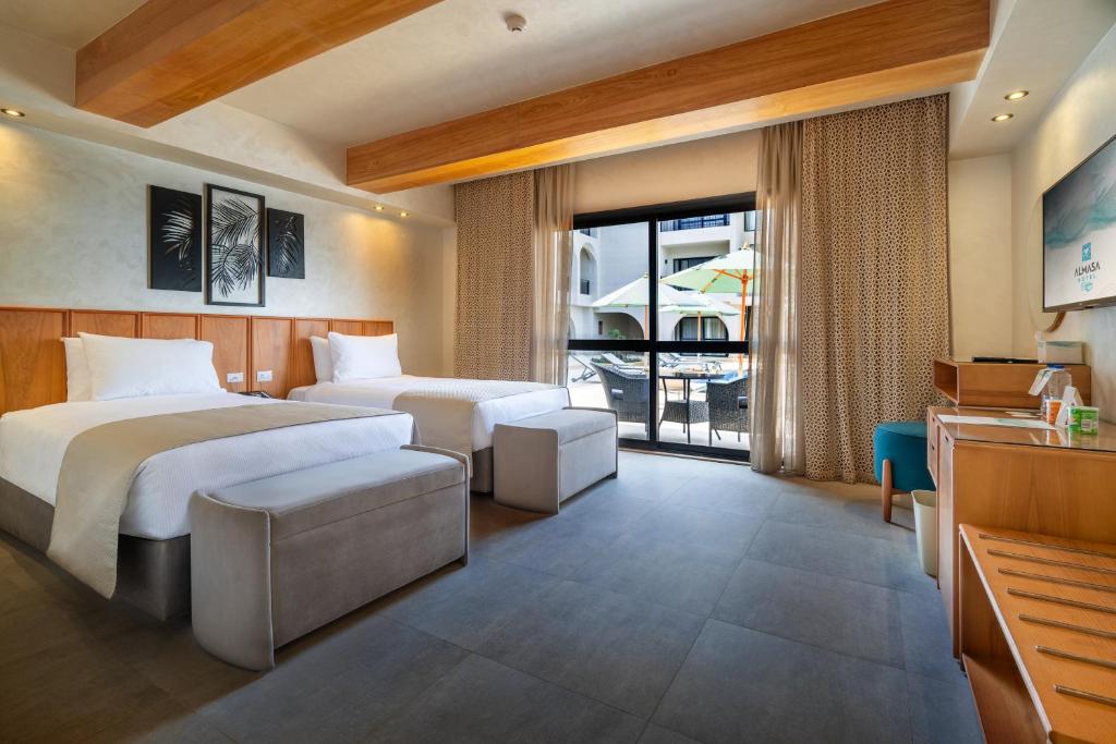 Al Masa Hotel El Sokhna في العين السخنة: غرفة فندق بها سريرين وشرفة
