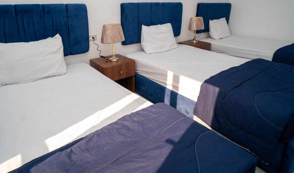 Fox House Beach Resort & Spa El Gouna في الغردقة: سريران في غرفة ذات لون أزرق وأبيض