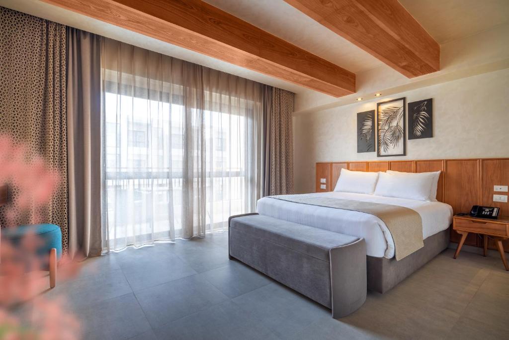 Al Masa Hotel El Sokhna في العين السخنة: غرفة فندق بها سرير ونافذة كبيرة