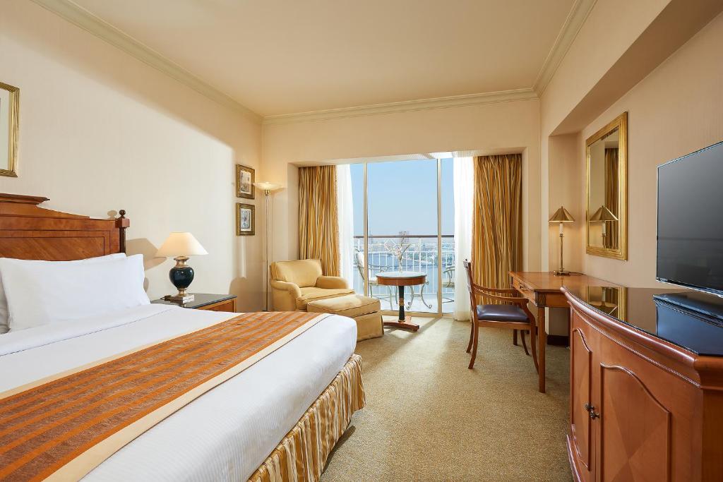 Hilton Cairo Grand Nile في القاهرة: غرفة فندق بها سرير ومكتب