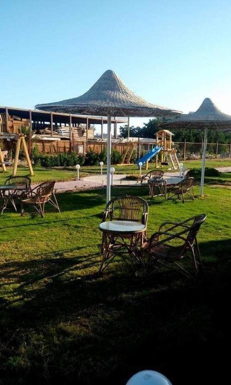 Fox House Beach Resort & Spa El Gouna في الغردقة: حديقة بها طاولة وكراسي وملعب