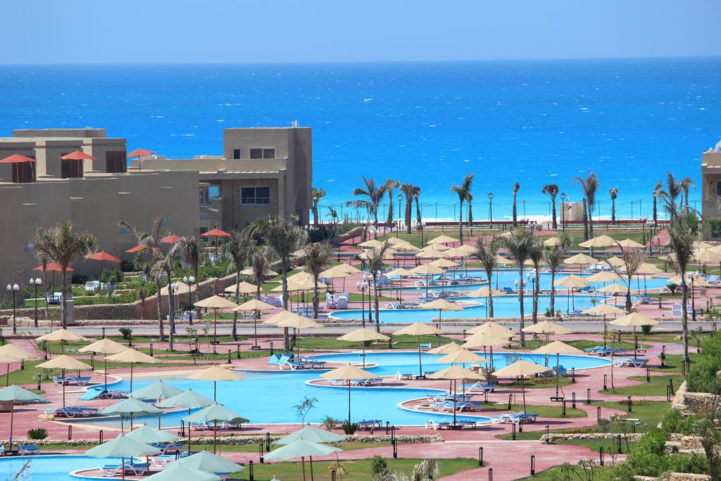 واجهة فندق توليب الساحل الشمالي المطلة على حمام السباحة والبحر